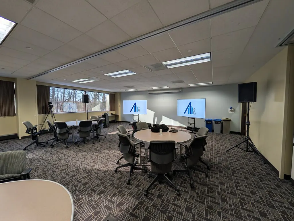 Conference room with displays showing the A&M logo