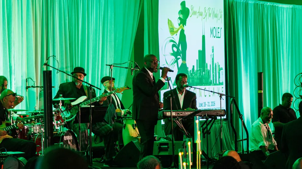 Jazz band performing beside The Moles Conclave branding showing June 18–21, 2026
